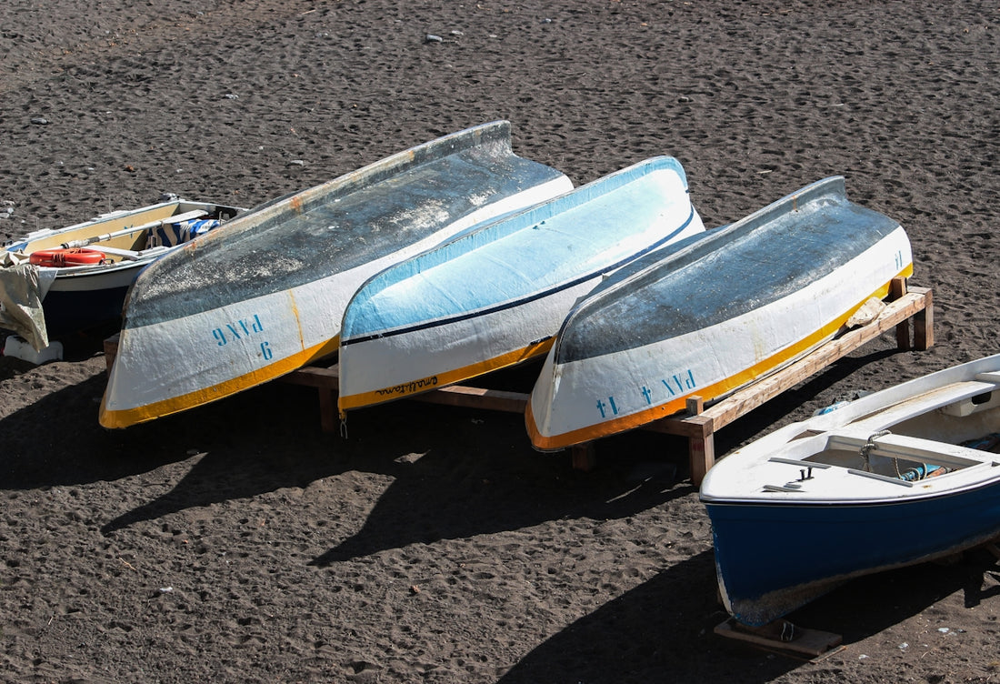a group of three boats sitting on top of a beach