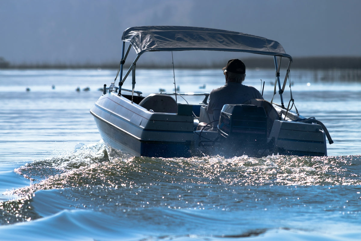 A man driving a boat across a body of water