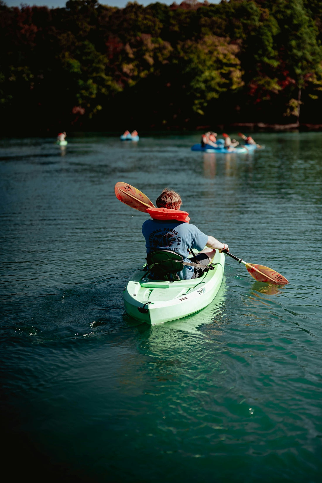 A man in a kayak paddling on a lake