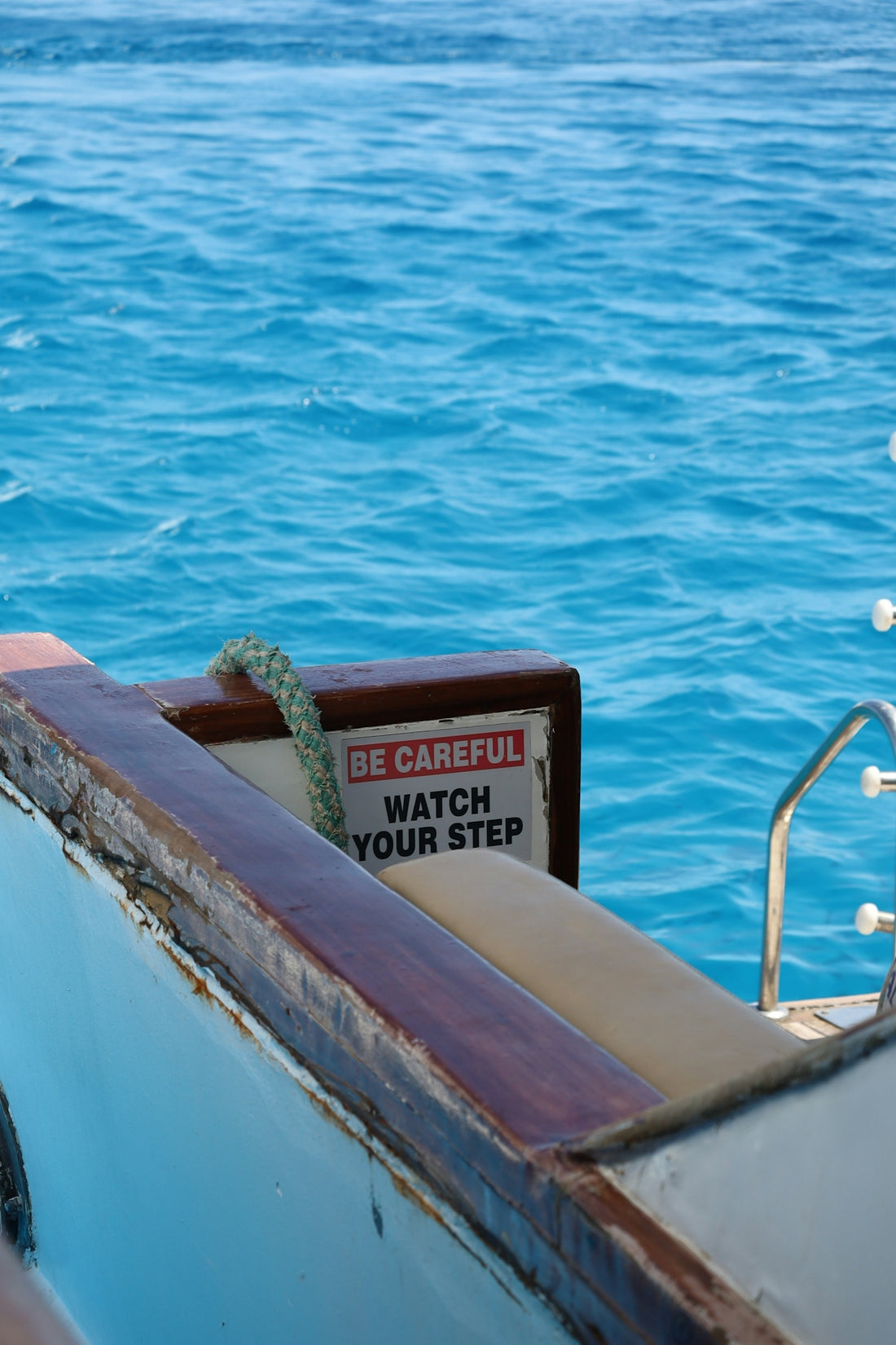 Warning sign on a boat deck overlooking blue ocean