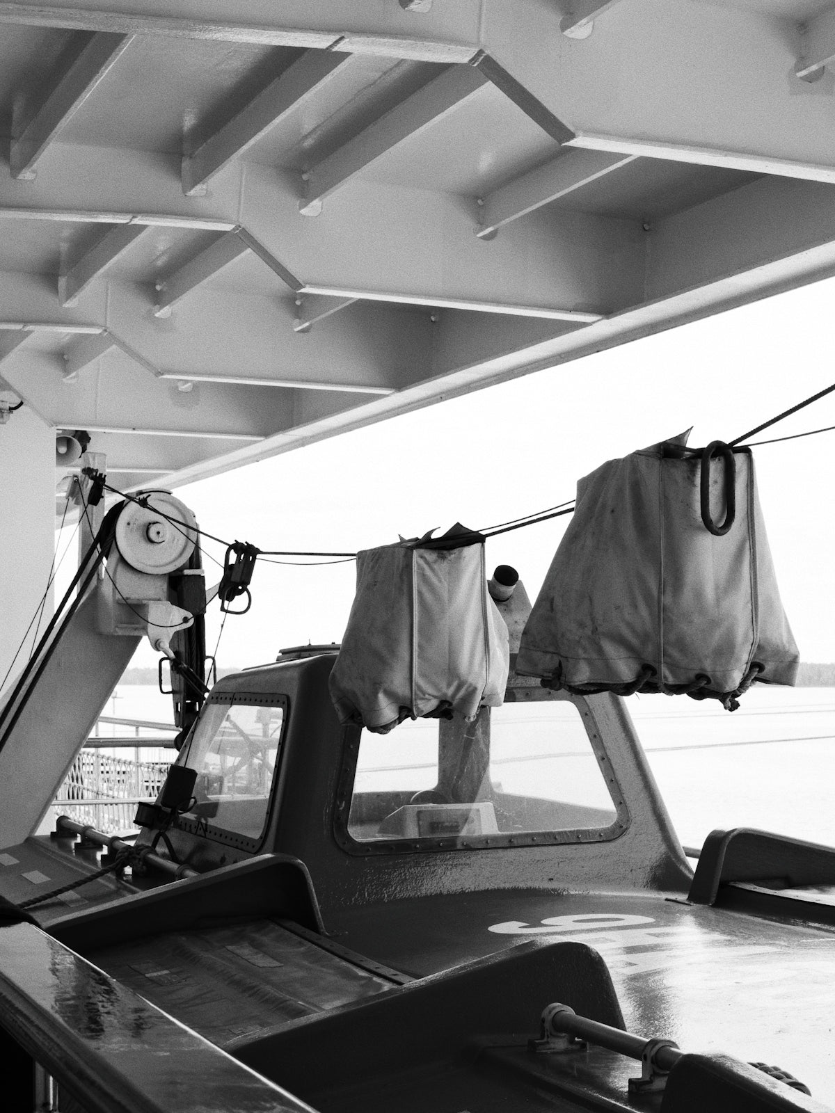 Lifeboat covered with protective tarps on a ship deck