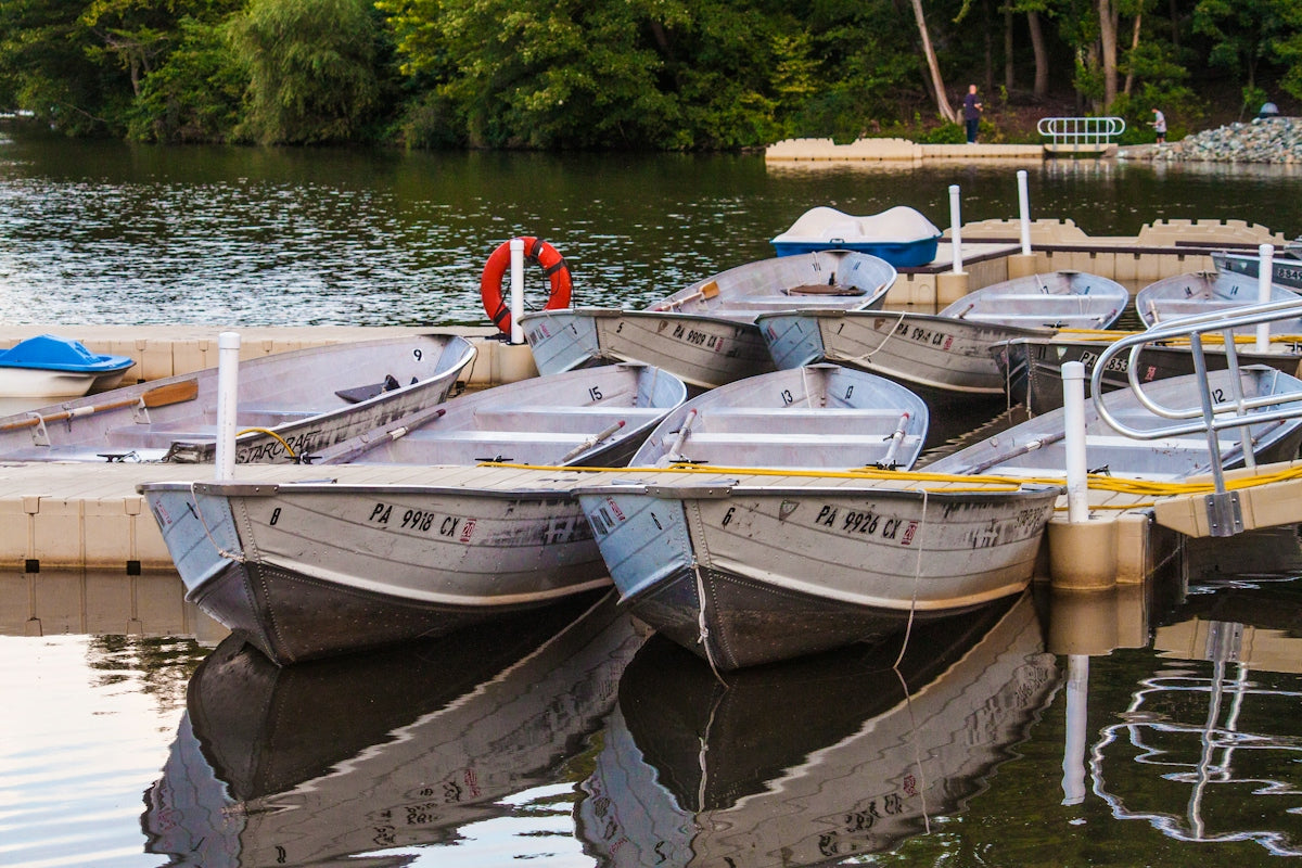 Several small boats docked on a calm lake