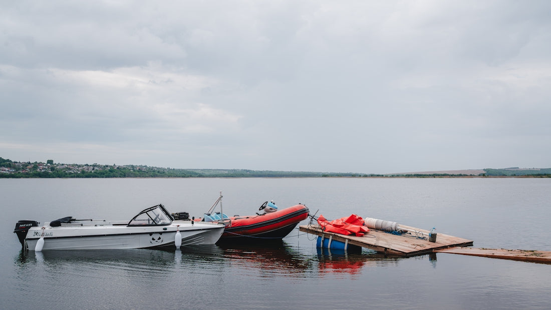 Three boats moored at a wooden jetty on a lake.